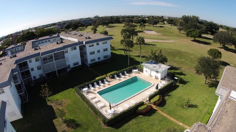 an aerial view of a pool with a yard