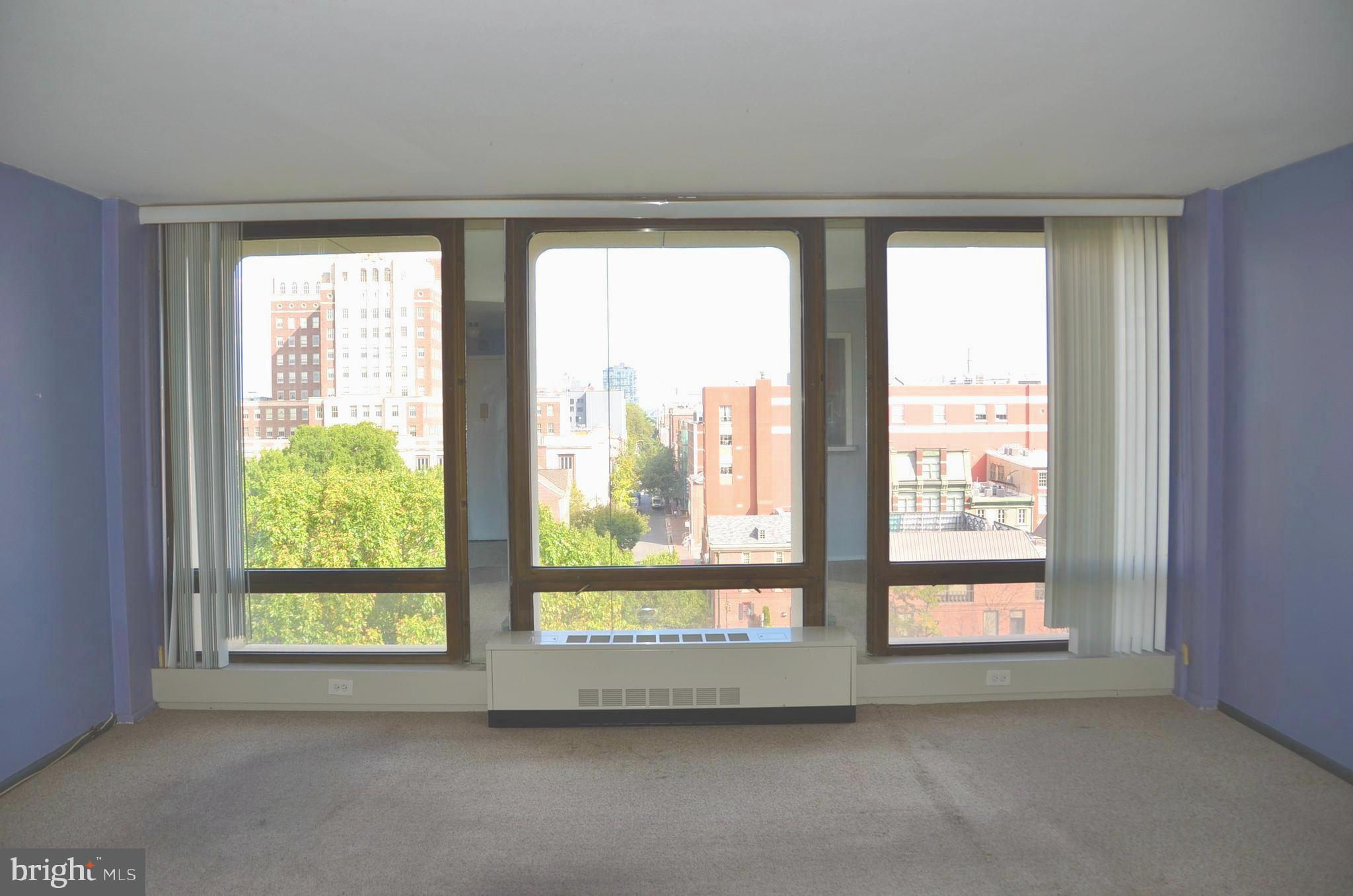 a view of room with a large window and front door