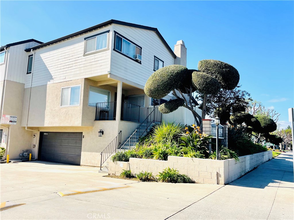 a front view of a house with a yard and potted plants