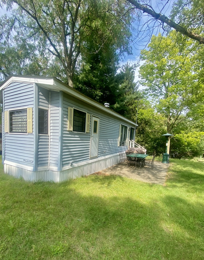 a backyard of a house with table and chairs