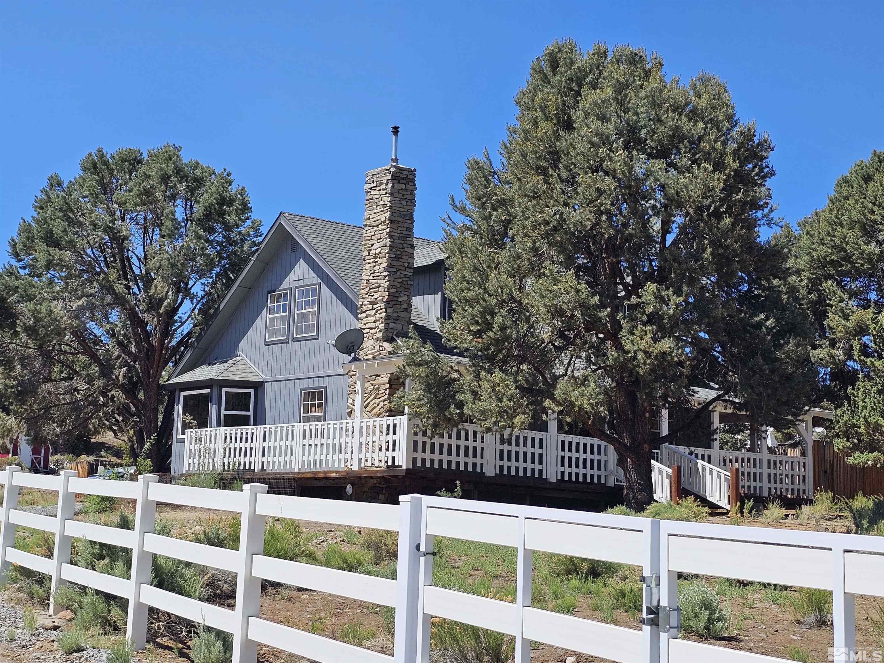 a front view of a house with a tree