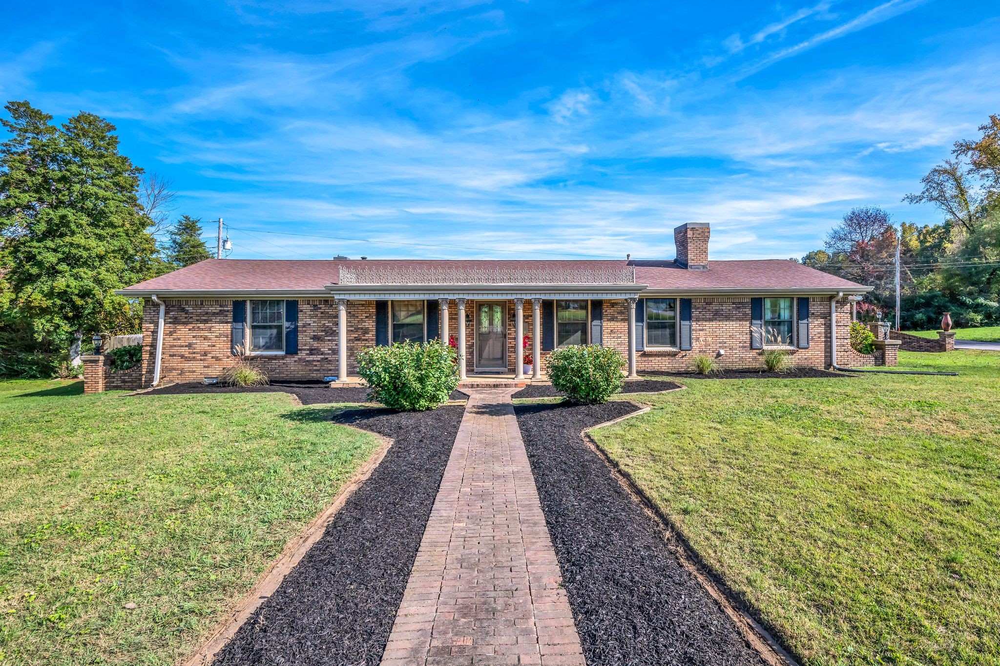 front view of a brick house with a yard