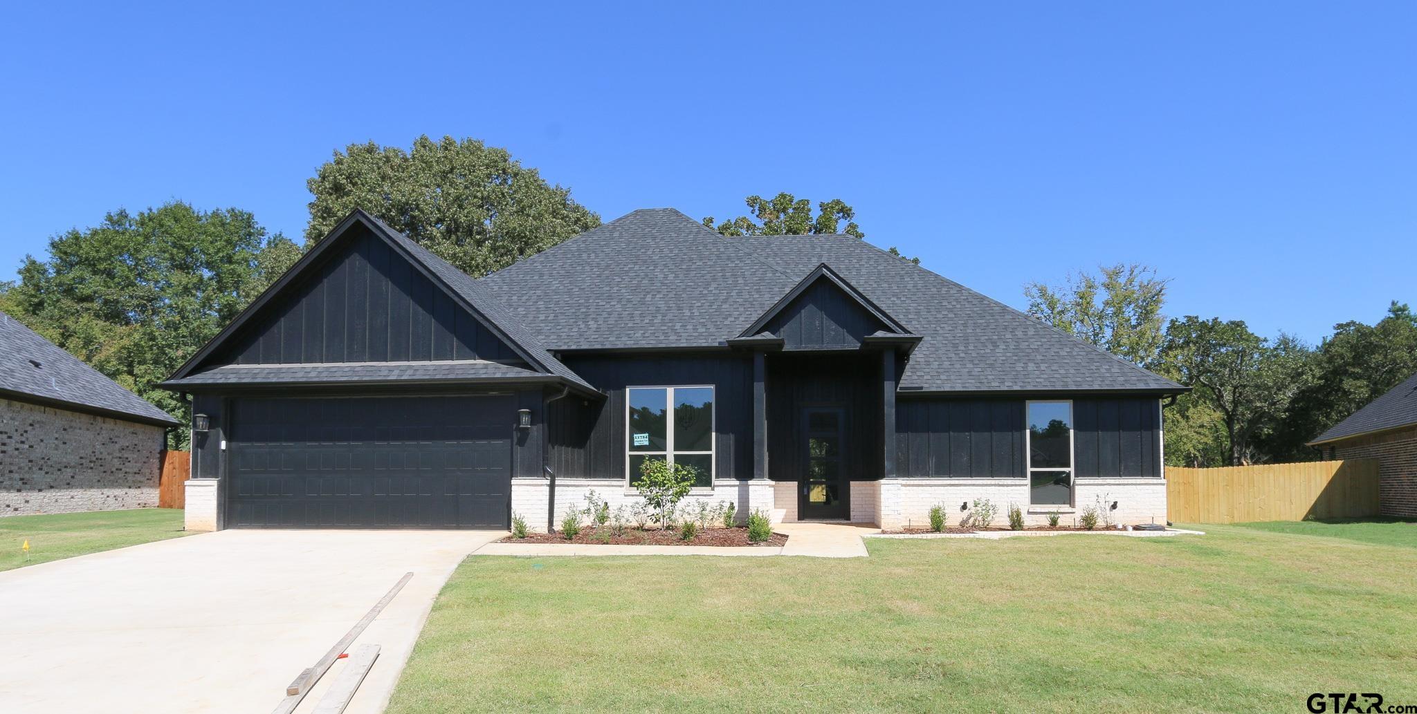 a front view of a house with a yard garage and outdoor seating