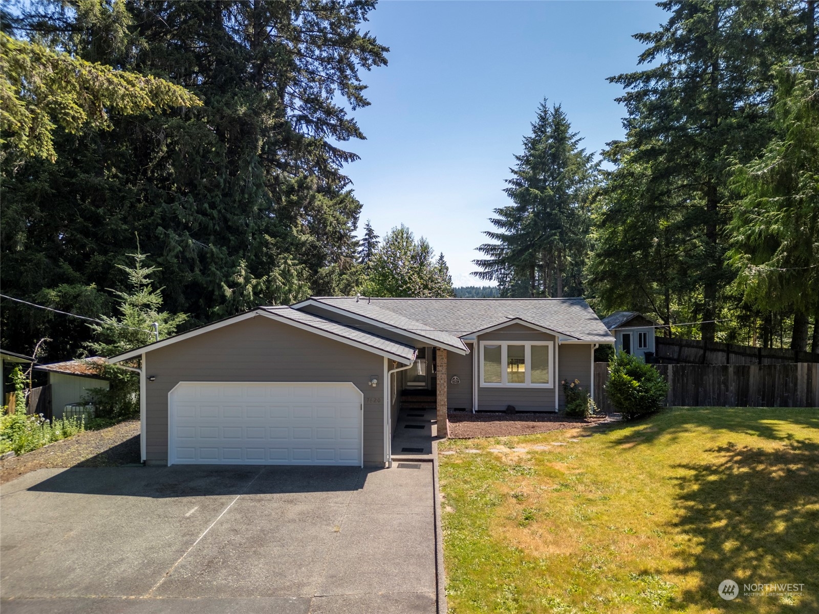 a front view of house with yard and trees in the background