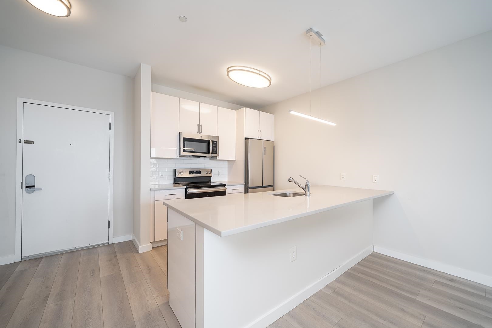 a kitchen with stainless steel appliances a refrigerator sink and microwave