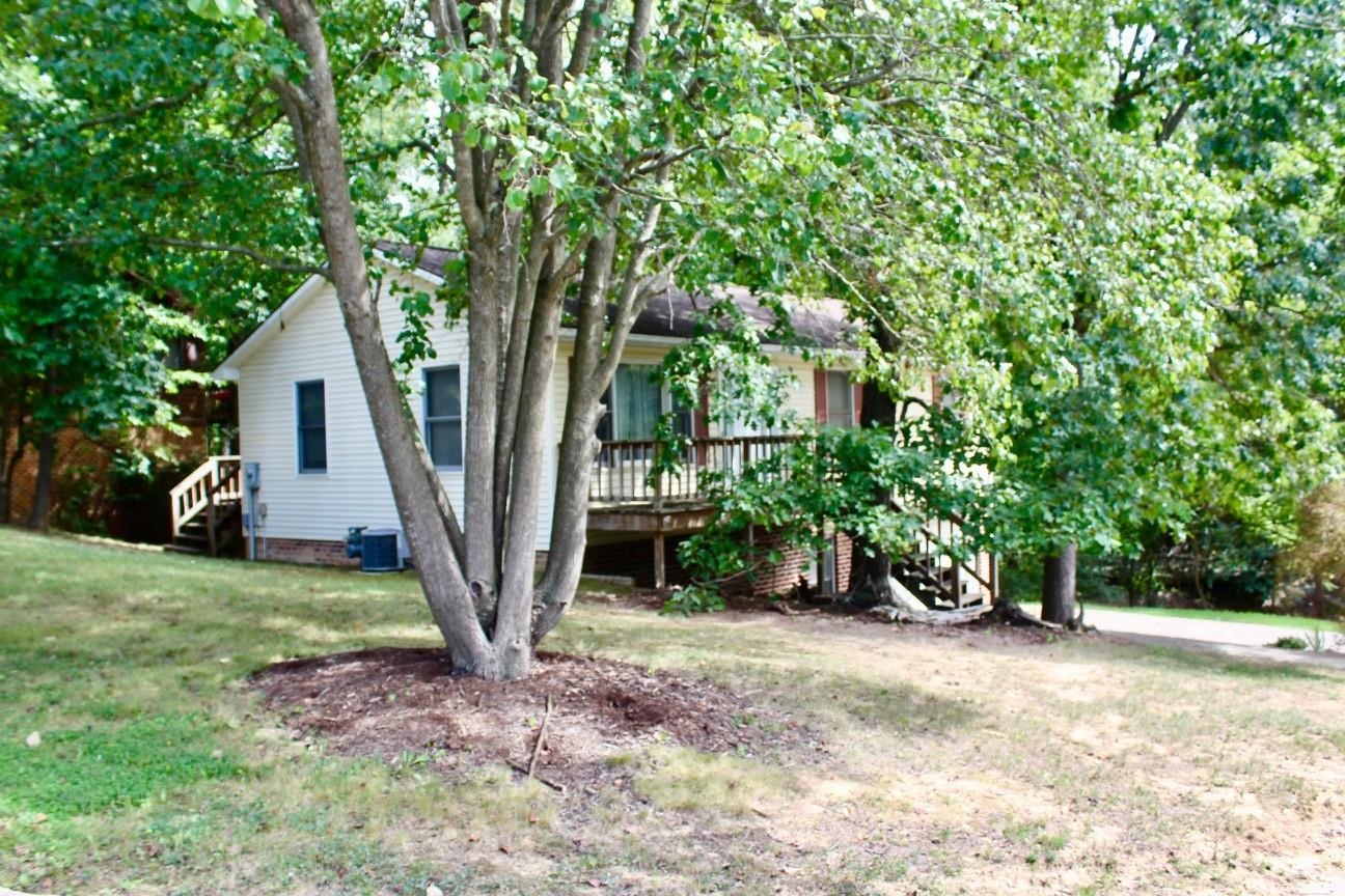 a view of a house with backyard and a tree