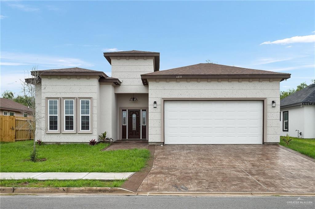 a front view of a house with a yard and garage