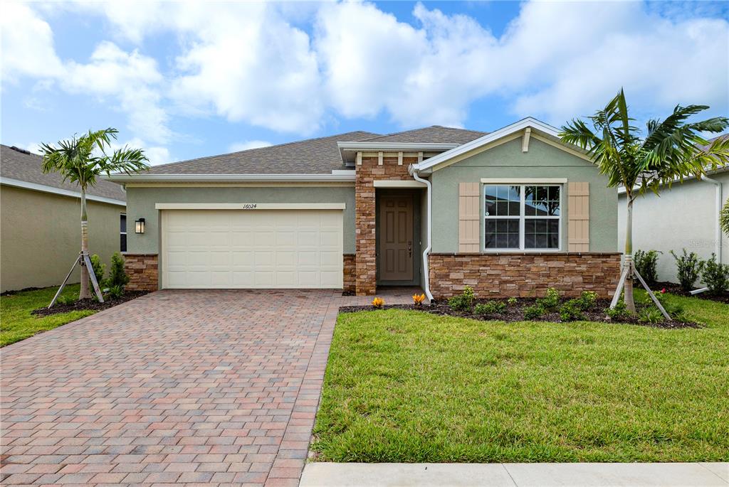 a front view of a house with a yard and garage