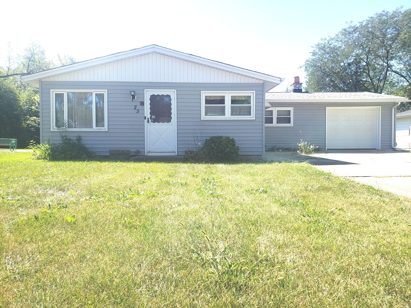 a front view of house with yard and trees around