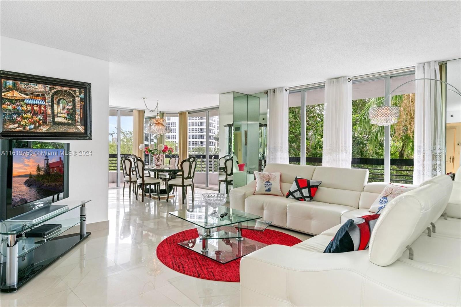 a living room with furniture flat screen tv and a large window