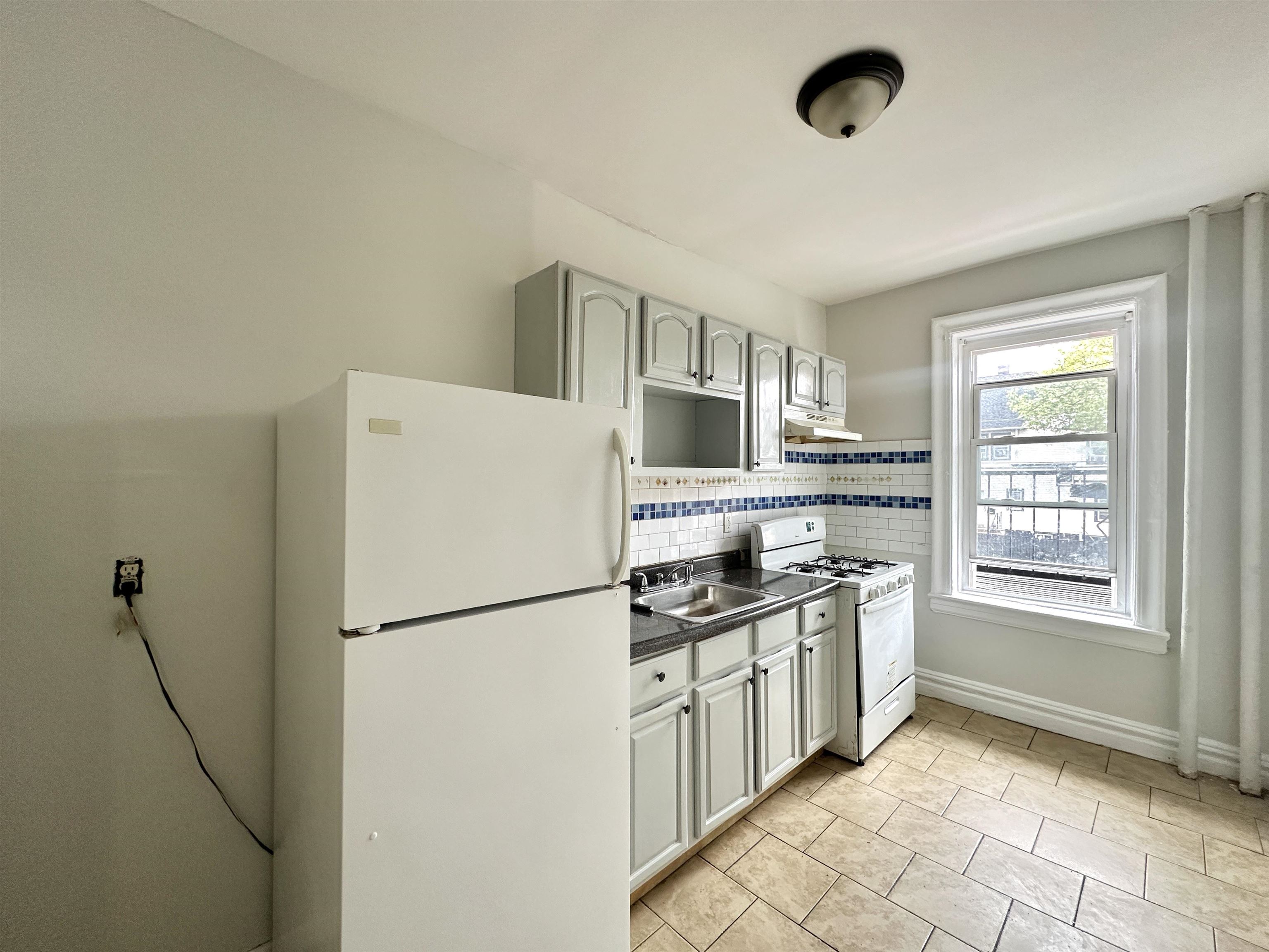 a kitchen with stainless steel appliances granite countertop a refrigerator stove sink and cabinets