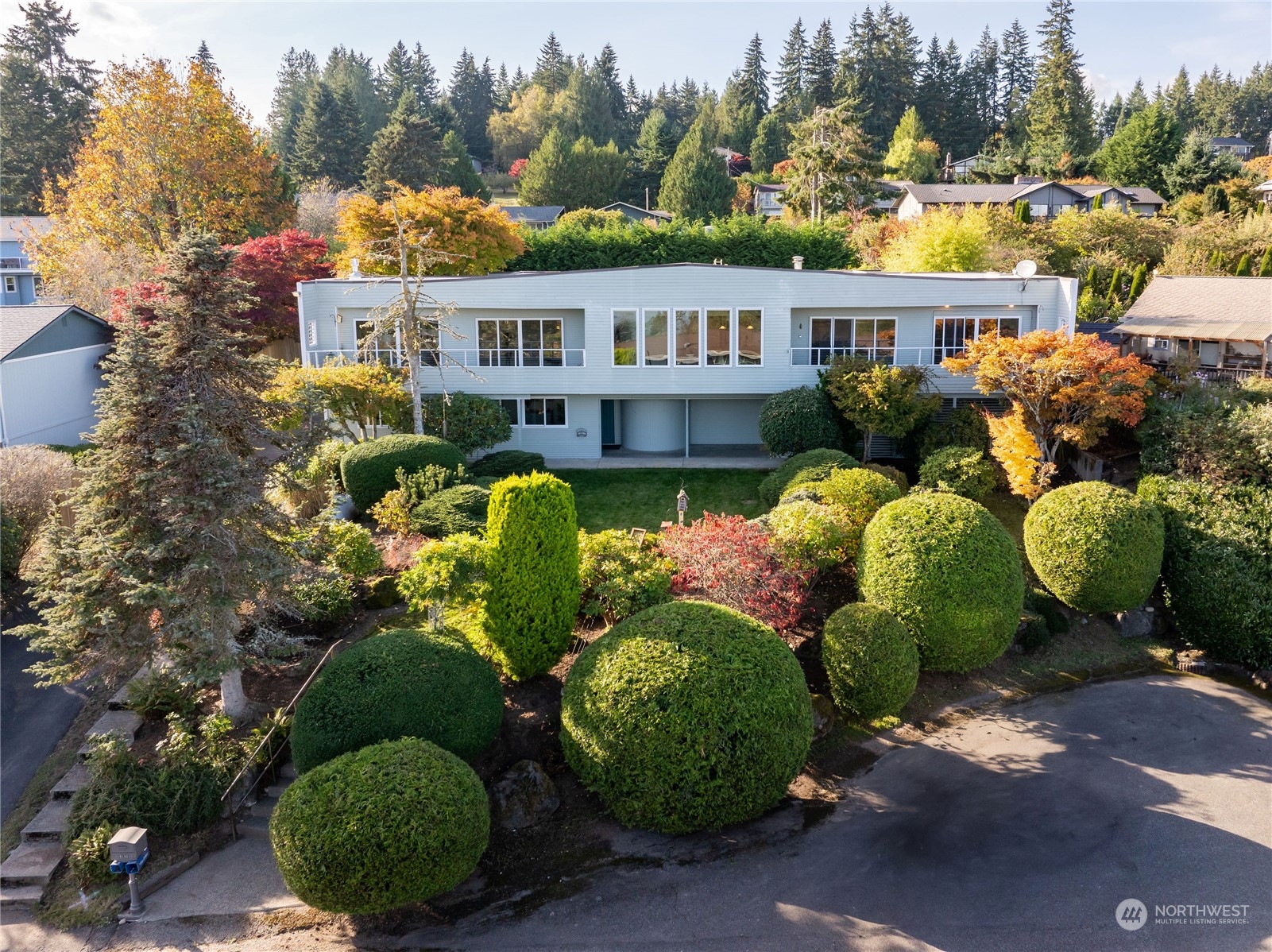 a view of a house with large trees and plants