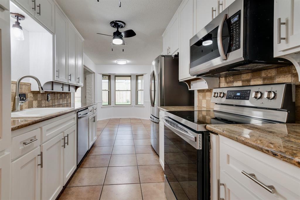 a kitchen with stainless steel appliances granite countertop a stove and a microwave