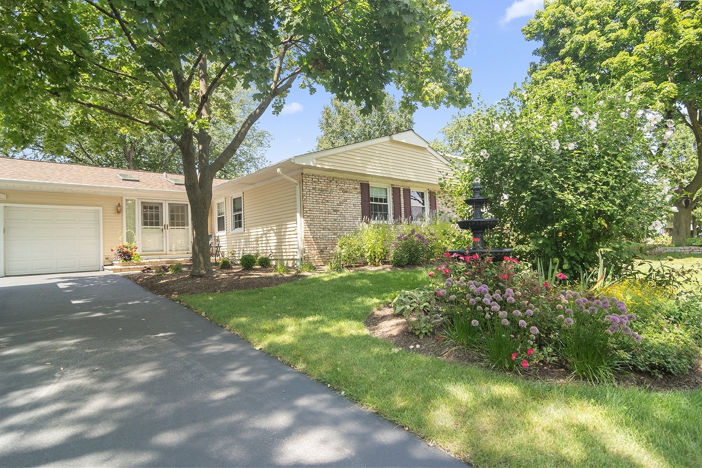 a front view of a house with yard and green space