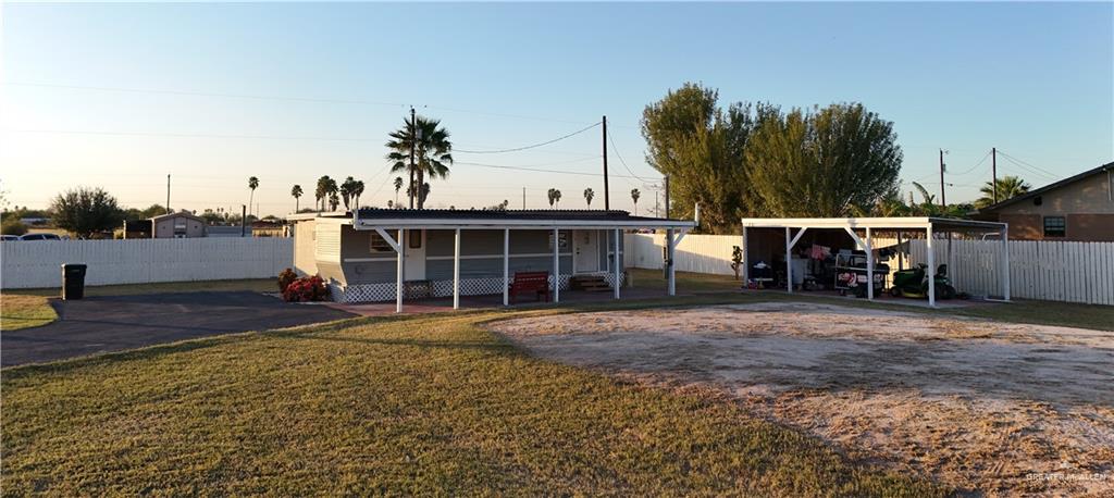 a view of a house with backyard and trees