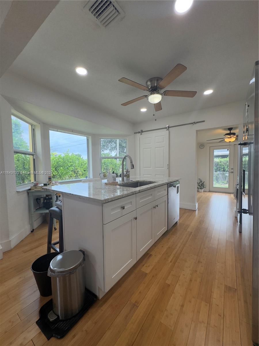 a kitchen with a sink and wooden floor