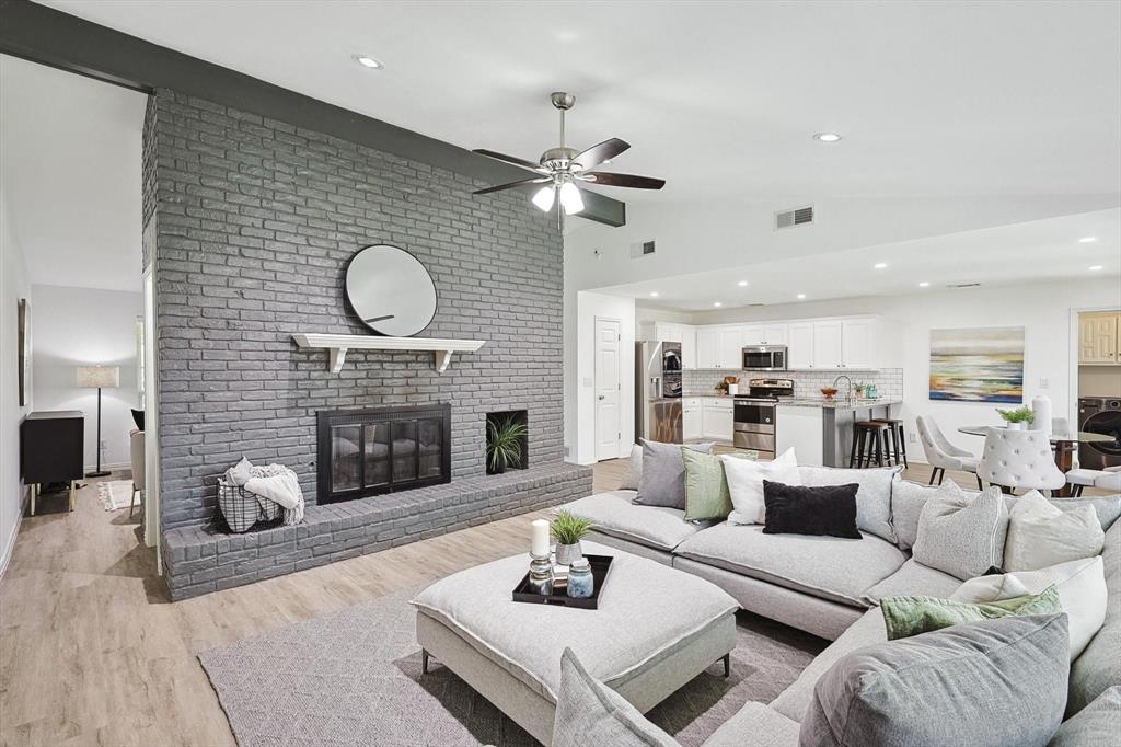 a living room with furniture a fireplace and kitchen view