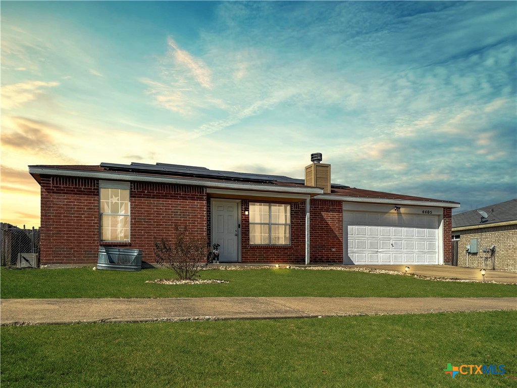 a front view of a house with a garden and yard