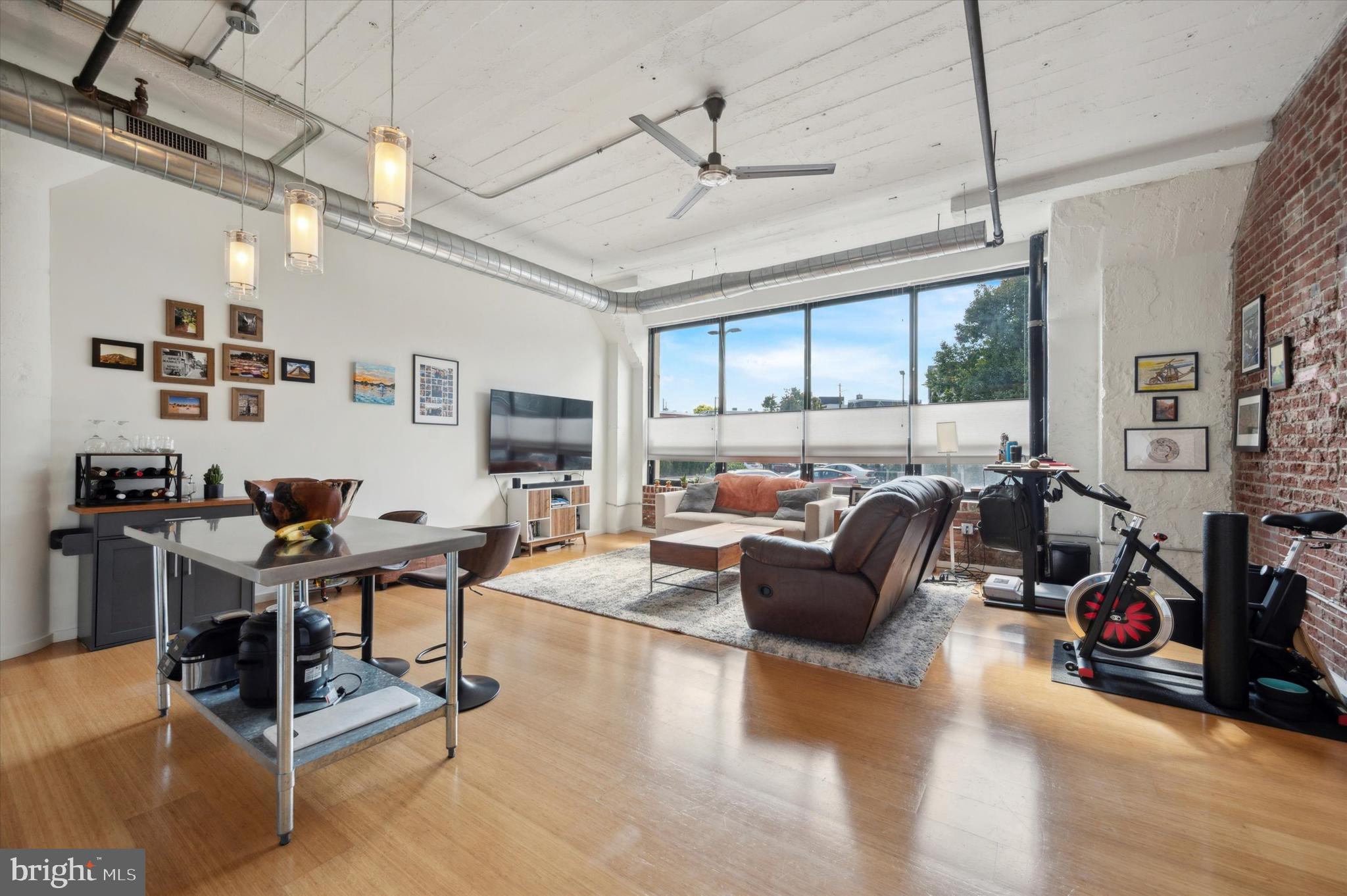 a living room with furniture gym equipment and a large window