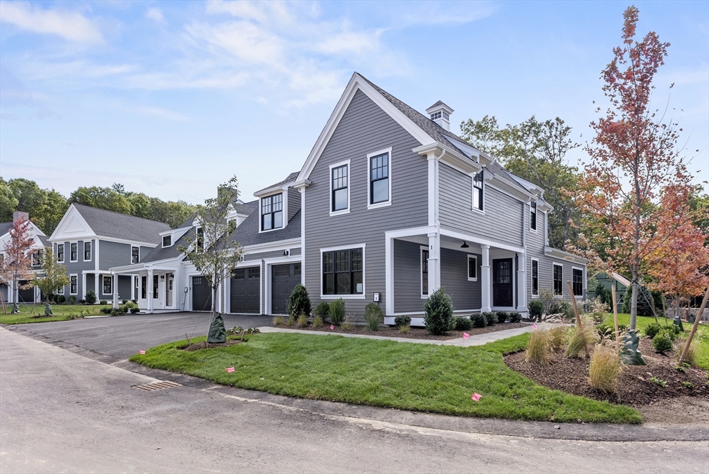 a front view of a house with a yard and potted plants