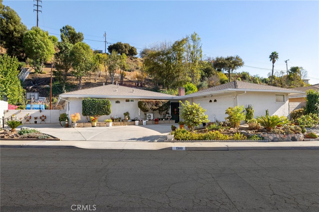 a front view of a house with a garden and mountain view