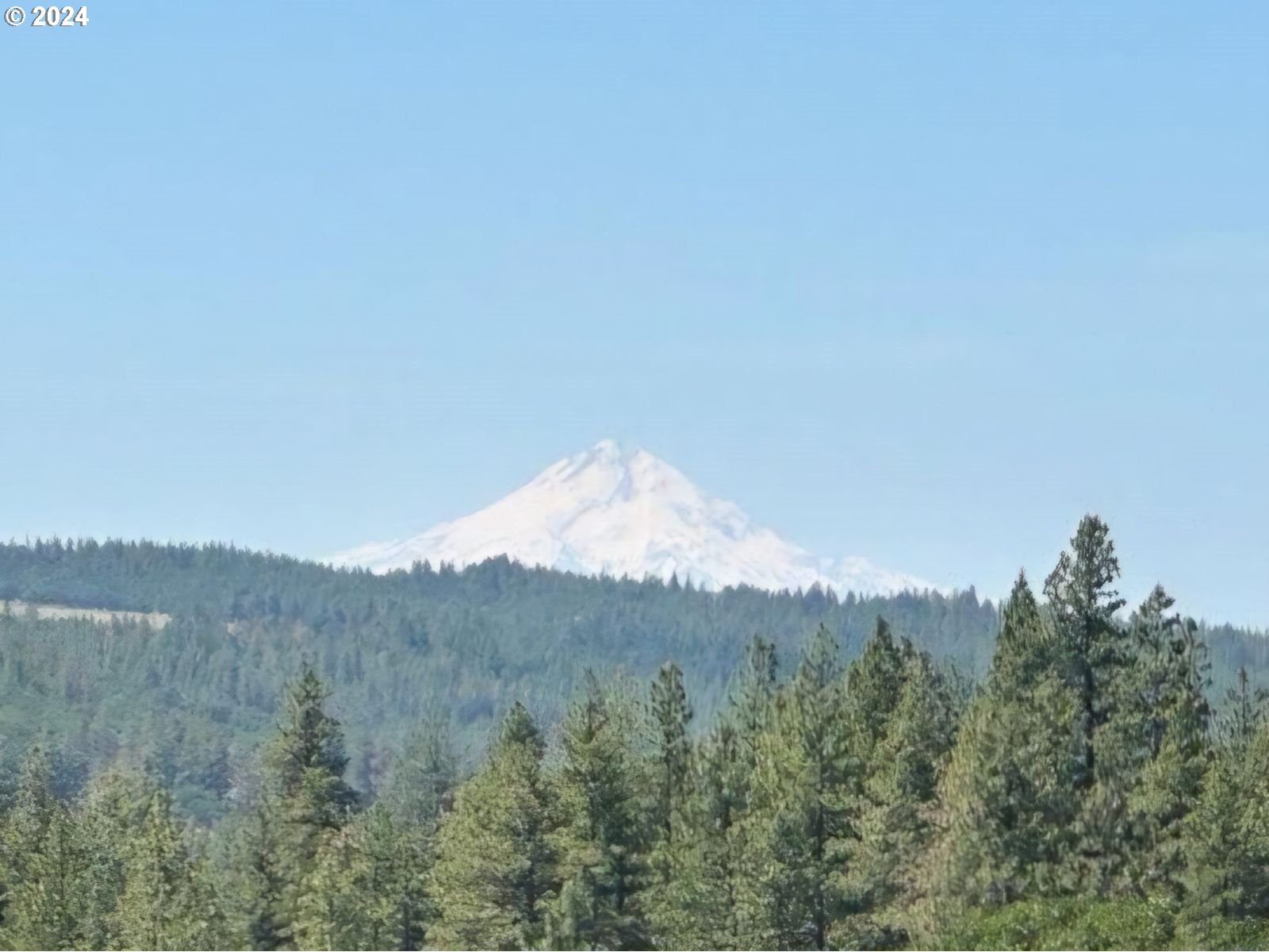 a view of a mountain range with trees in the background