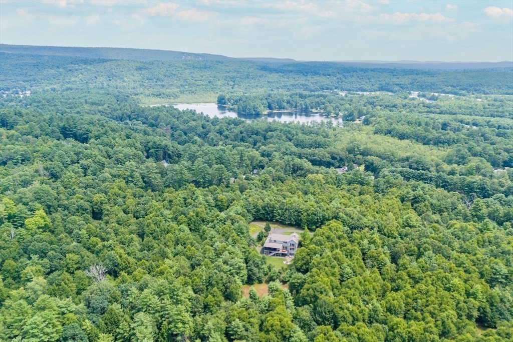 an aerial view of residential houses with outdoor space and trees