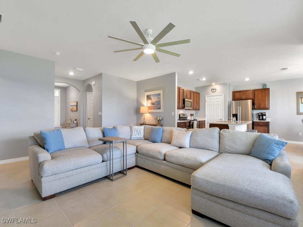 a living room with furniture kitchen view and a chandelier