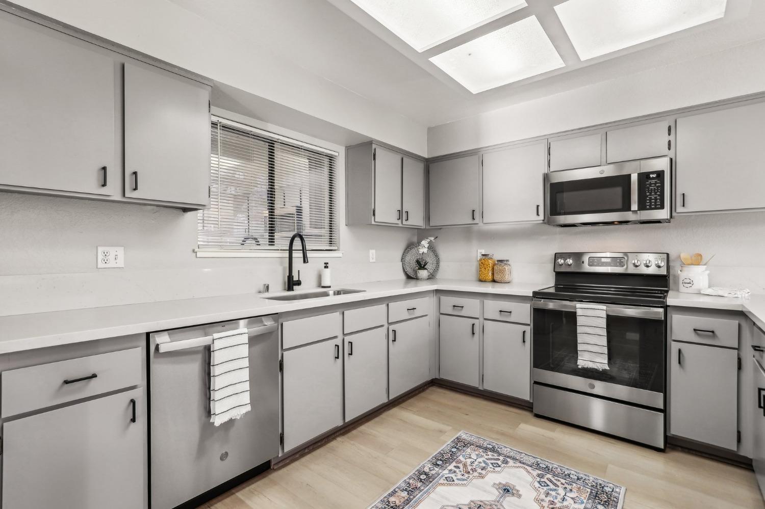 a kitchen with sink cabinets and stainless steel appliances