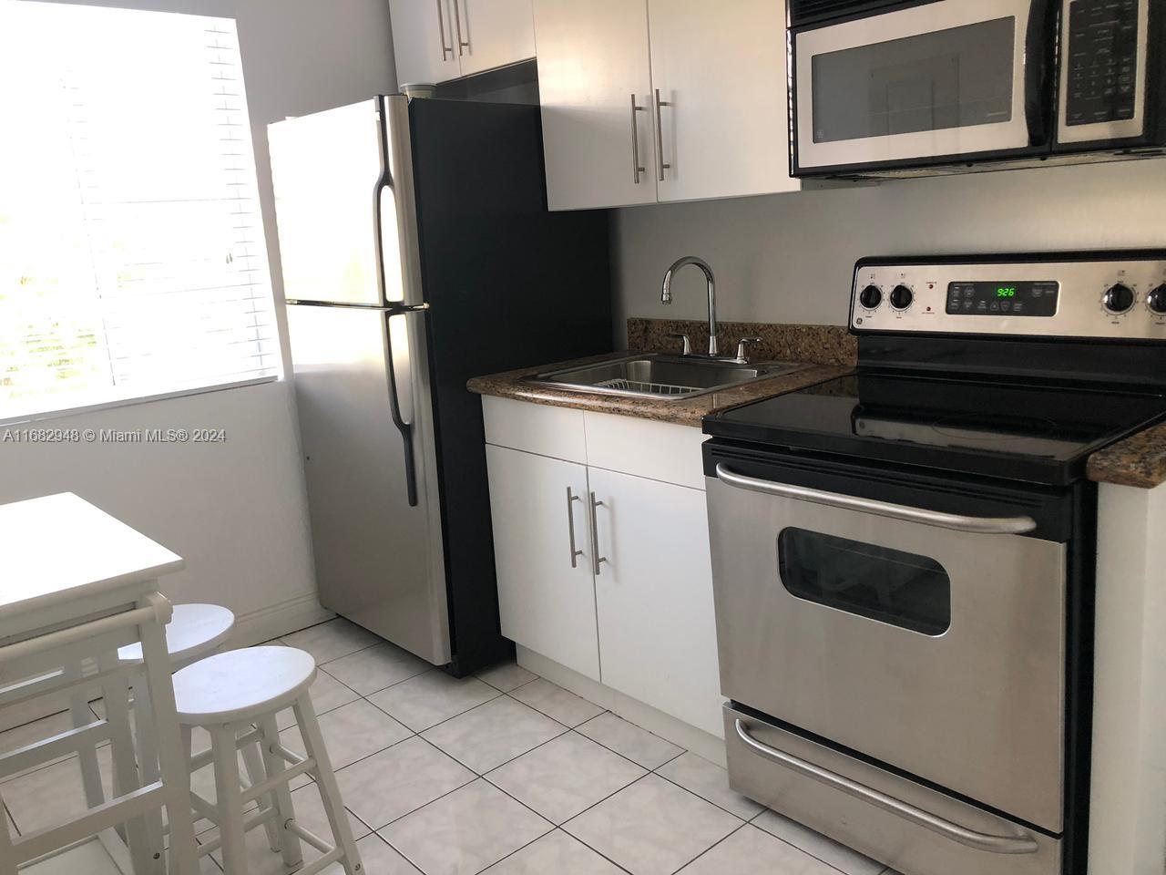 a kitchen with a refrigerator and a stove