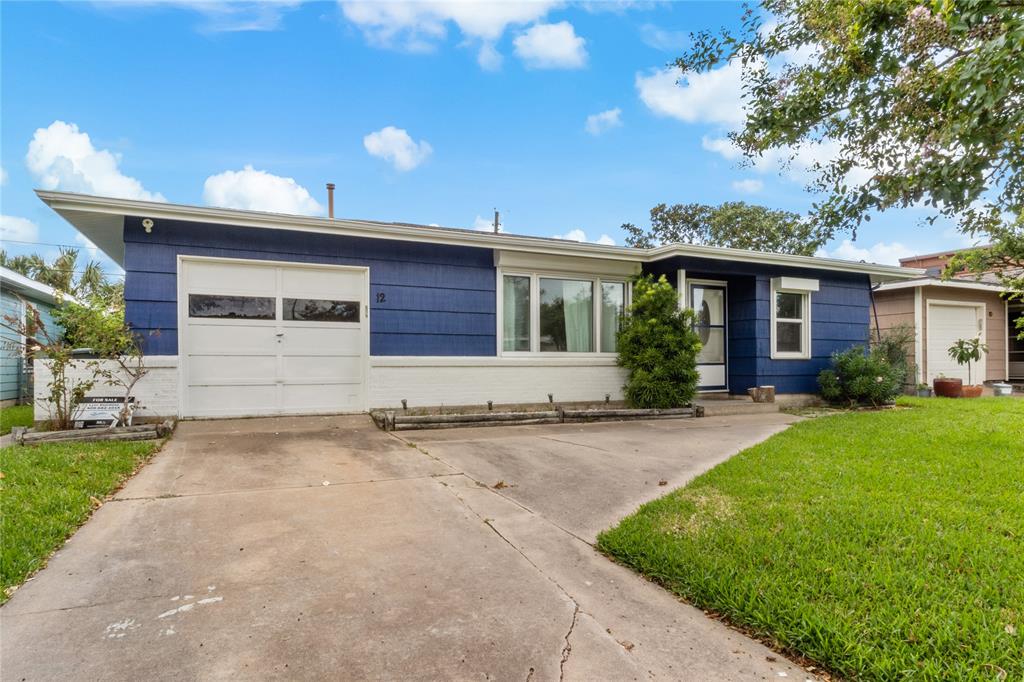 front view of a house with a yard and a garage