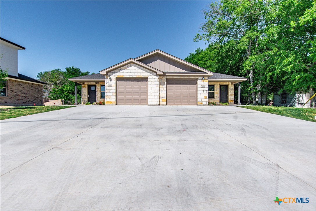 a front view of a house with yard and trees