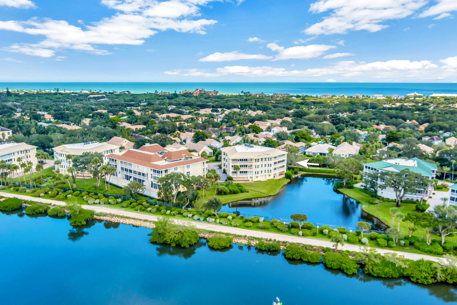 an aerial view of residential houses with outdoor space and lake view