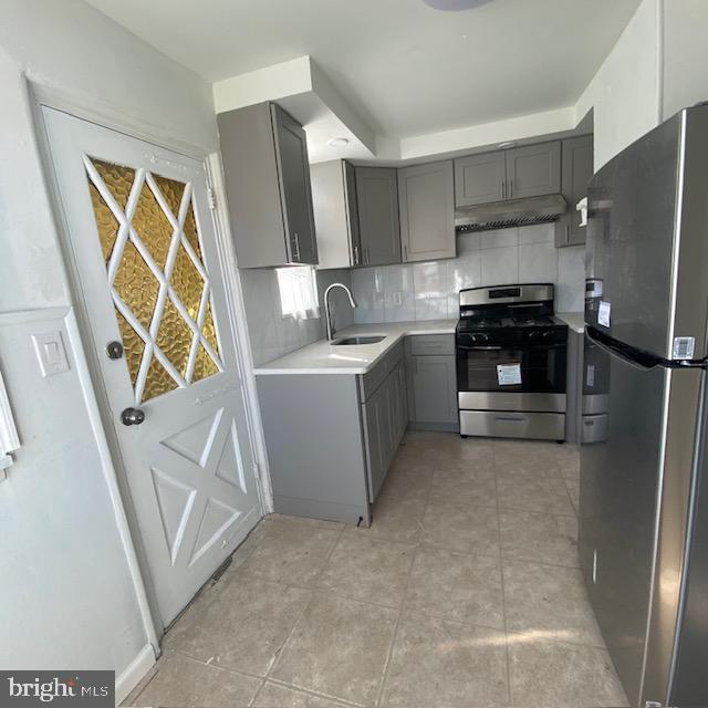 a kitchen with stainless steel appliances a stove a refrigerator and a sink