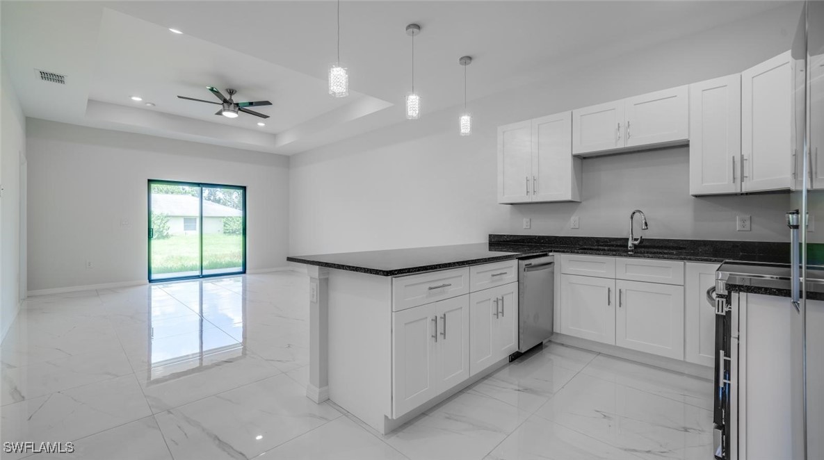 a kitchen with granite countertop cabinets stainless steel appliances a window and a sink