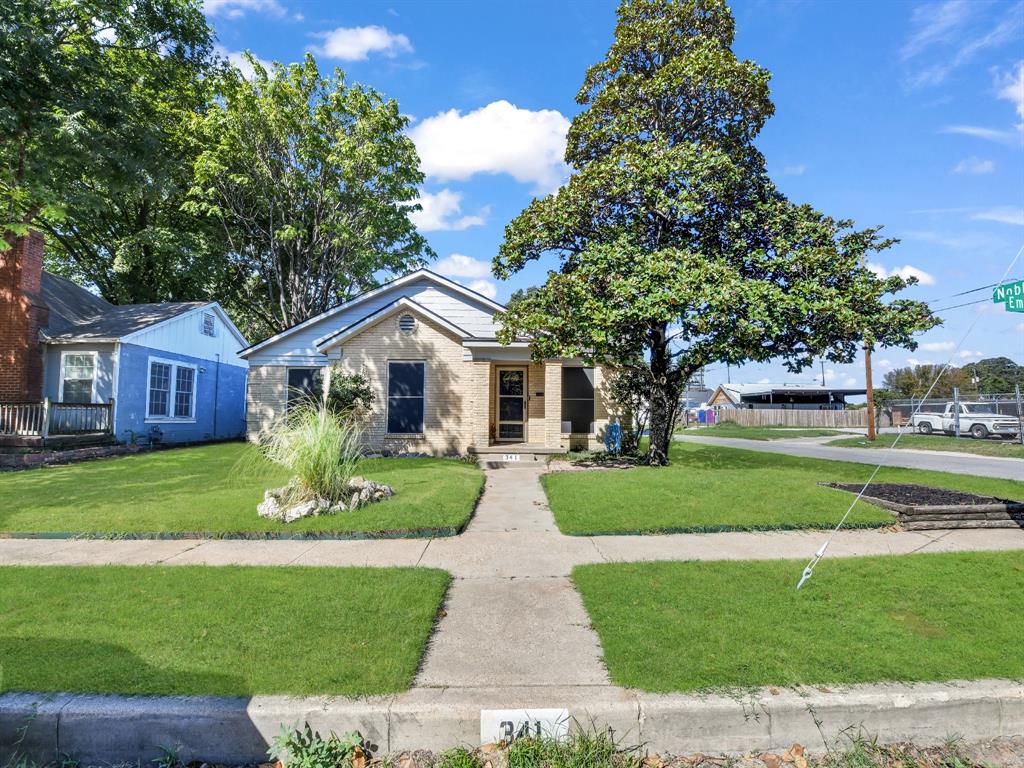 a front view of a house with a garden and trees