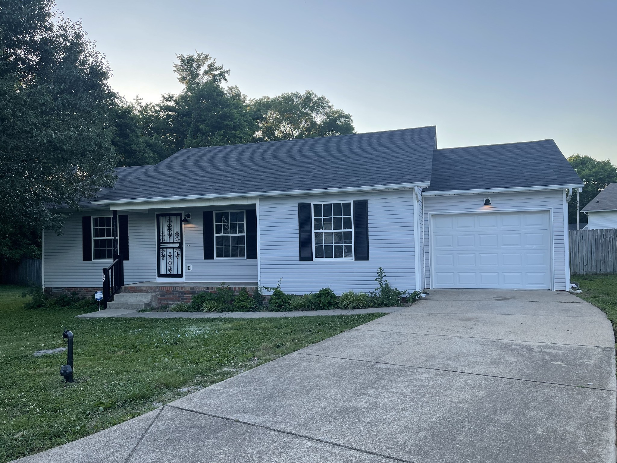 a front view of a house with a yard and trees