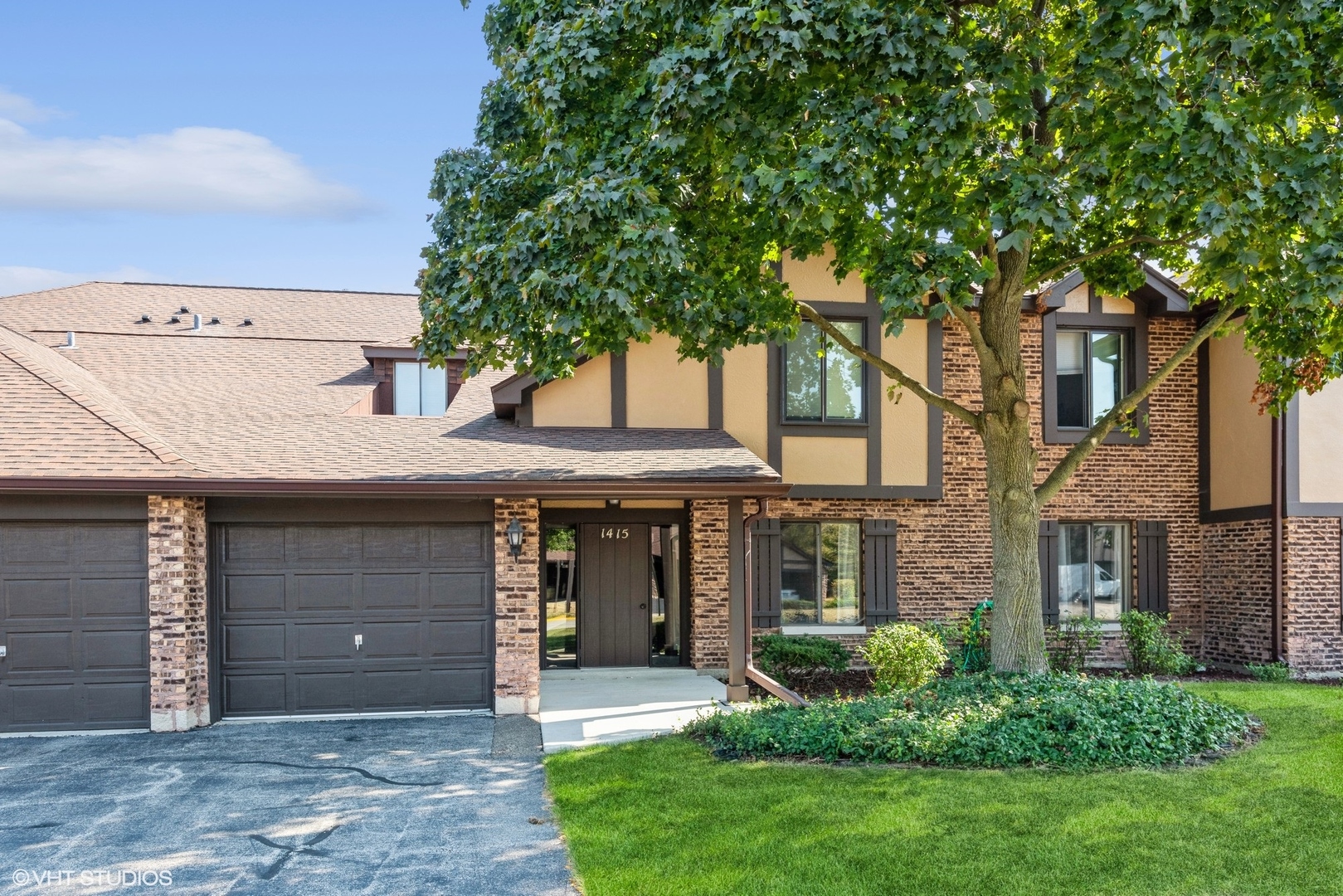 front view of a brick house with a yard