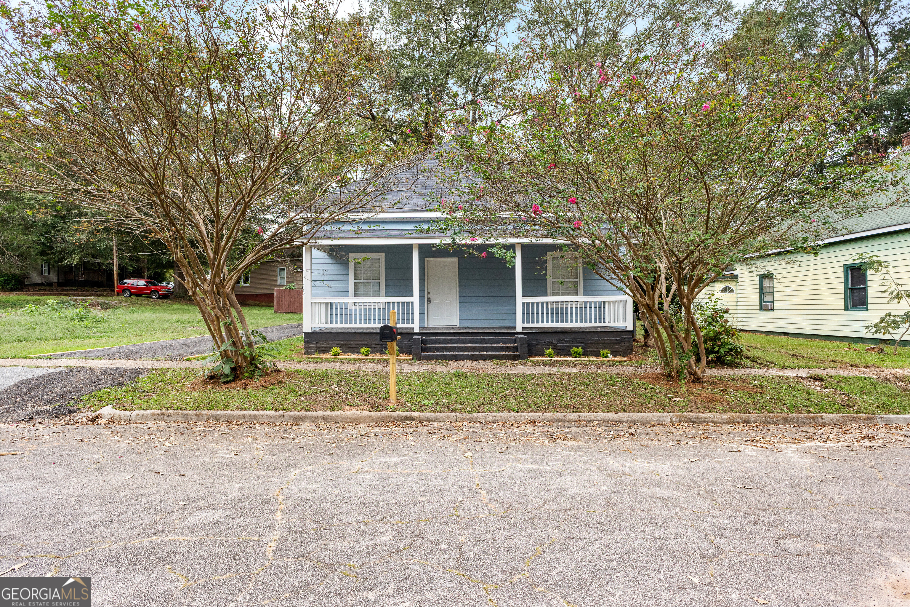 a view of large house with a big yard and large trees