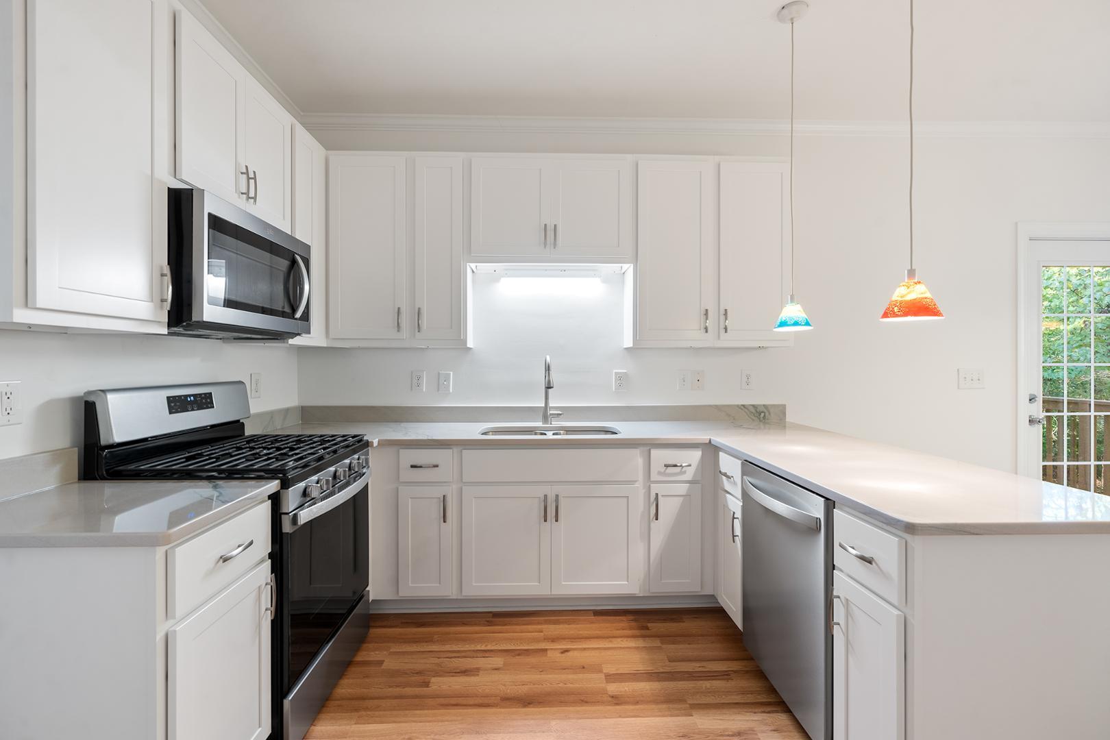 a kitchen with stainless steel appliances granite countertop a sink stove and microwave