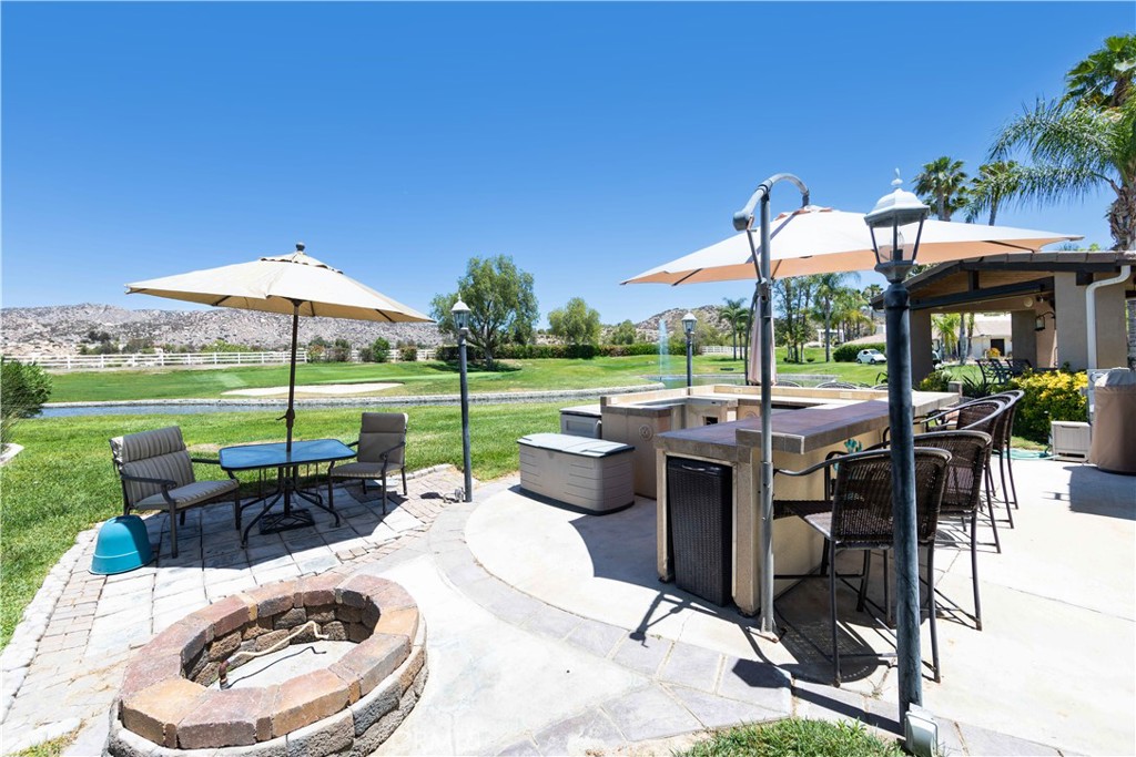 a view of a patio with a dining table and chairs under an umbrella