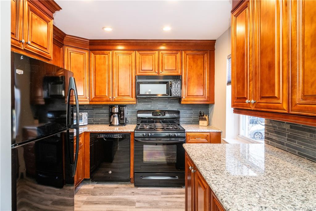 a kitchen with stainless steel appliances granite countertop a refrigerator a stove and a sink