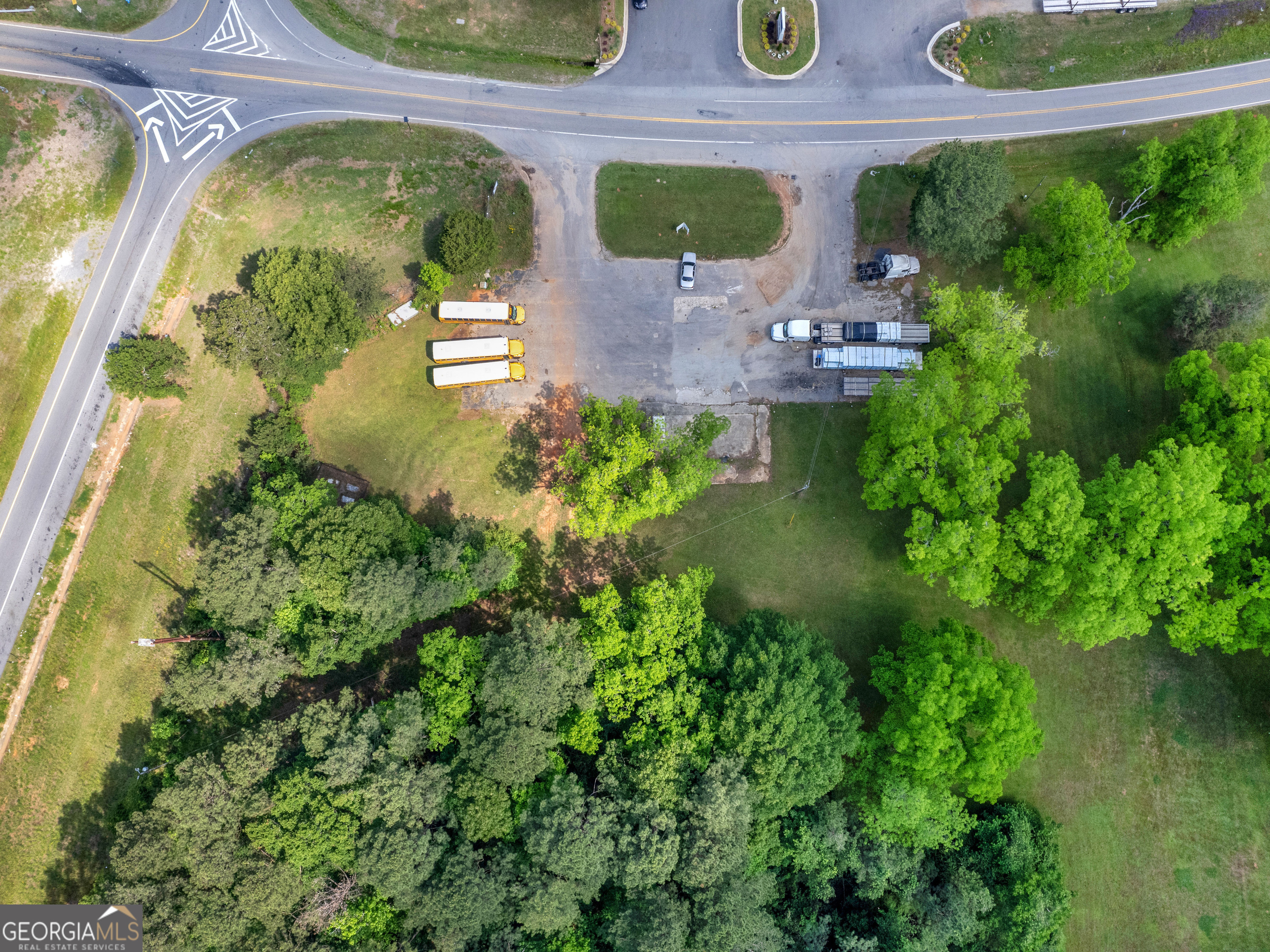 an aerial view of residential house with outdoor space and trees all around