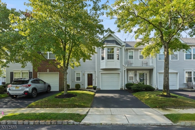 a front view of a house with a yard and trees