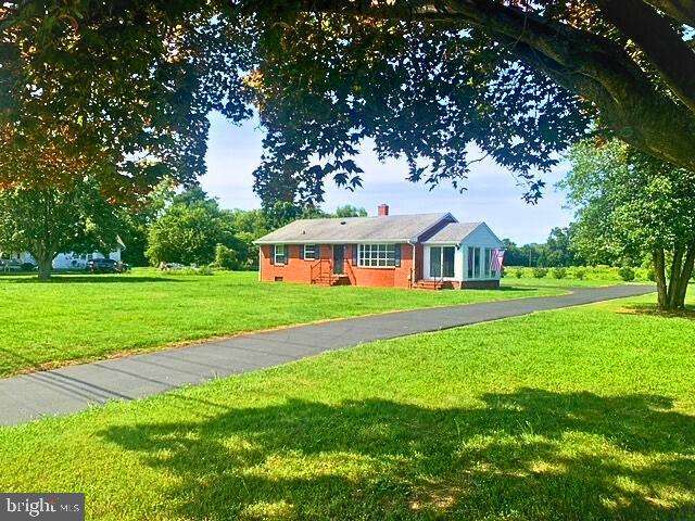 a front view of house with yard and green space