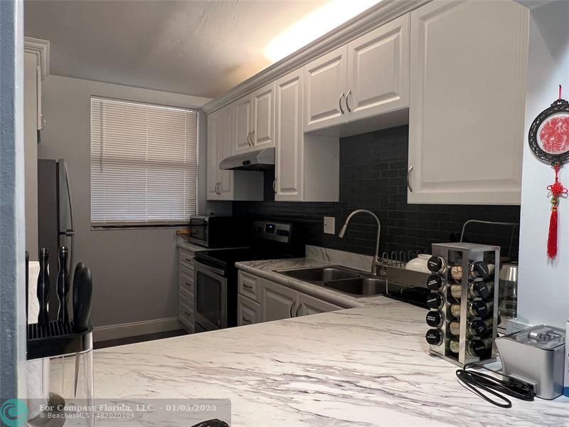 a kitchen with granite countertop a stove and a sink