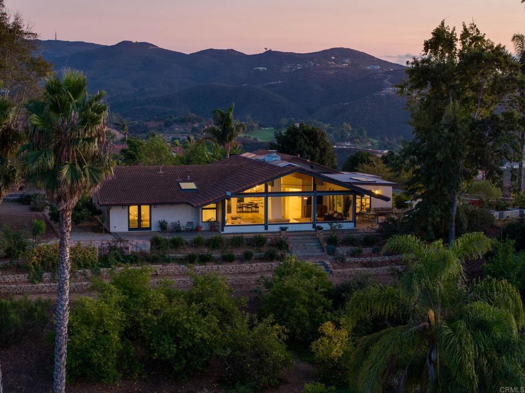 a view of a house with a field and a mountain view