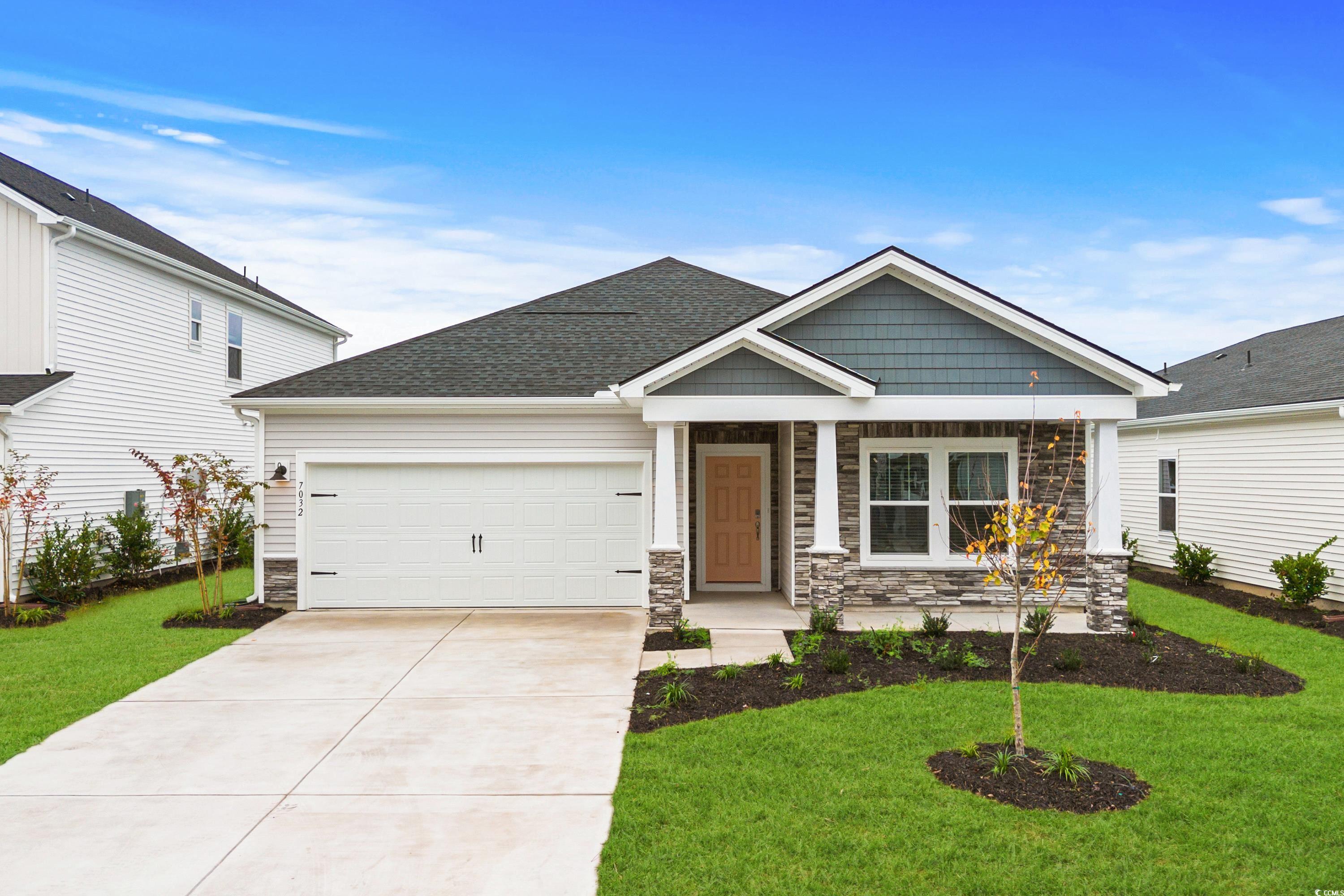 Craftsman-style house with a front yard and a gara