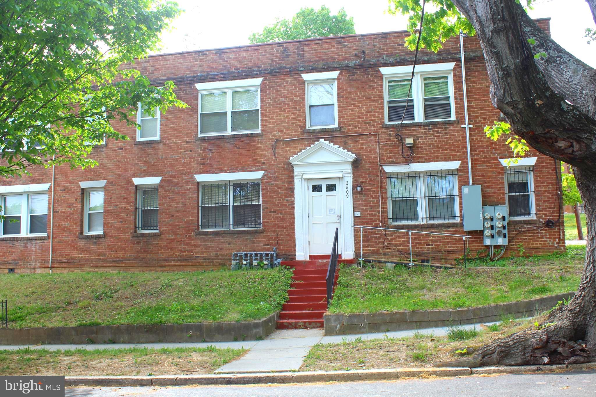 front view of a brick house with a yard