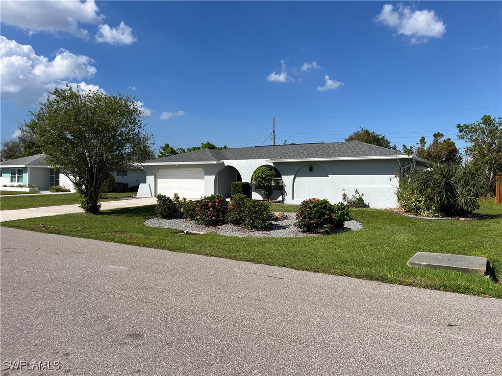 a view of a house with a big yard and large tree